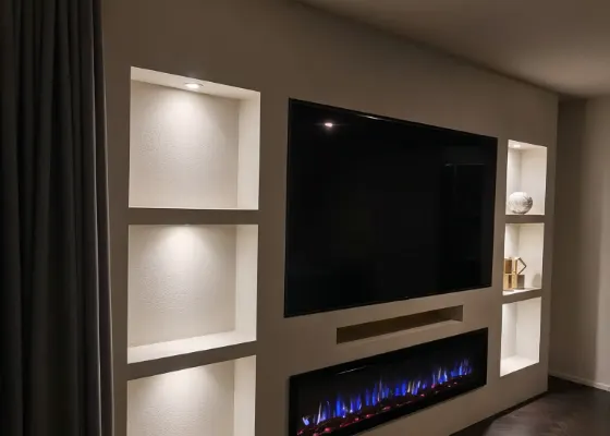 Cinewall met sfeerhaard, soundbarvak en verlichte vakken, voorbeeld van cinewallcenter