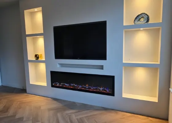 Cinewall met sfeerhaard, soundbarvak en verlichte vakken, voorbeeld van cinewallcenter